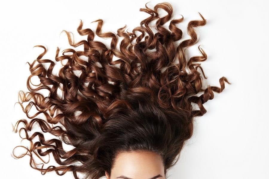 krecone-wlosy-i-czesc-twarzy-kobiety-patrzacej-w-kamere-min